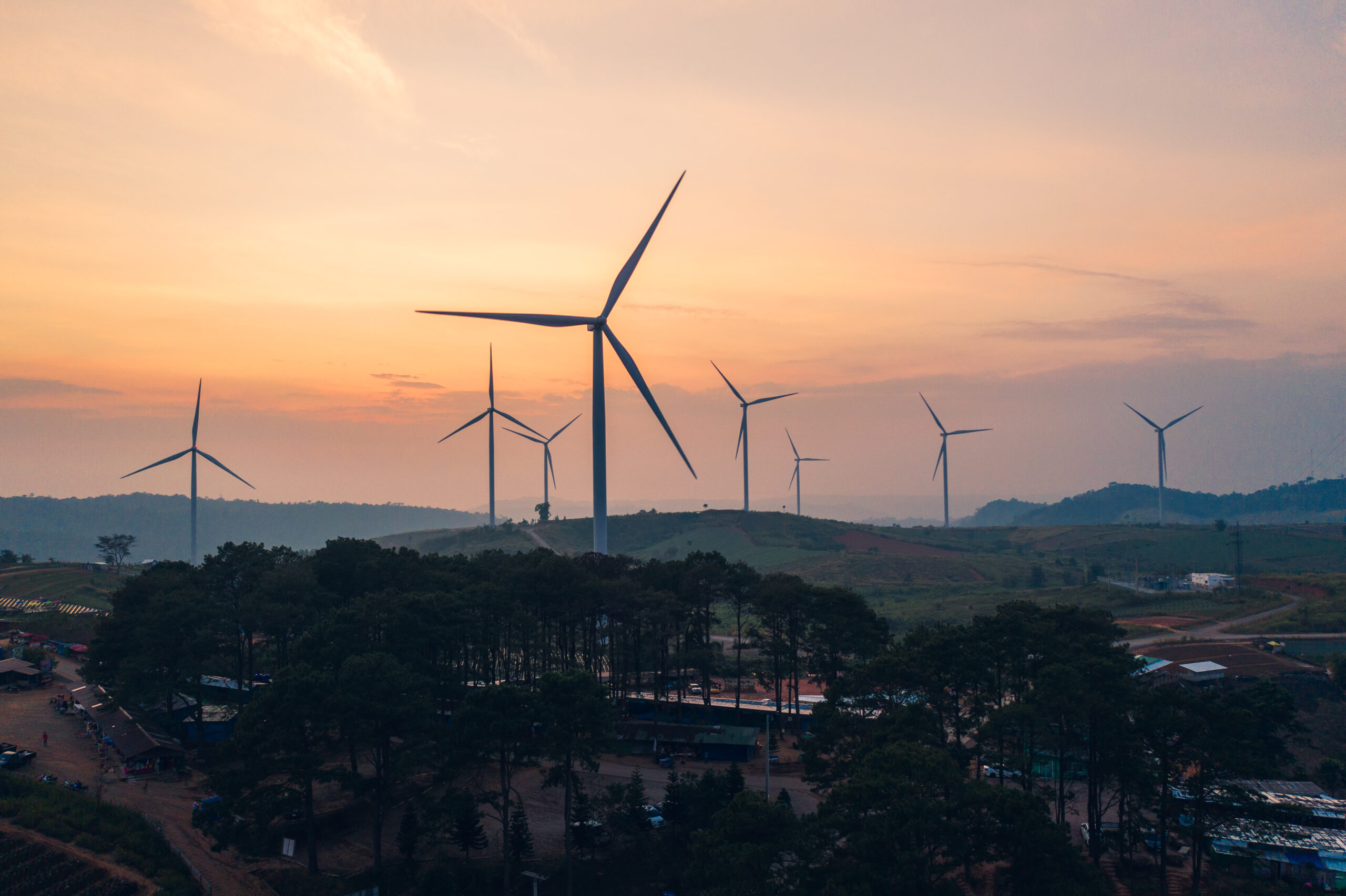 Wind turbines of alternative energy with clean and renewable on hill in agriculture fields at the evening